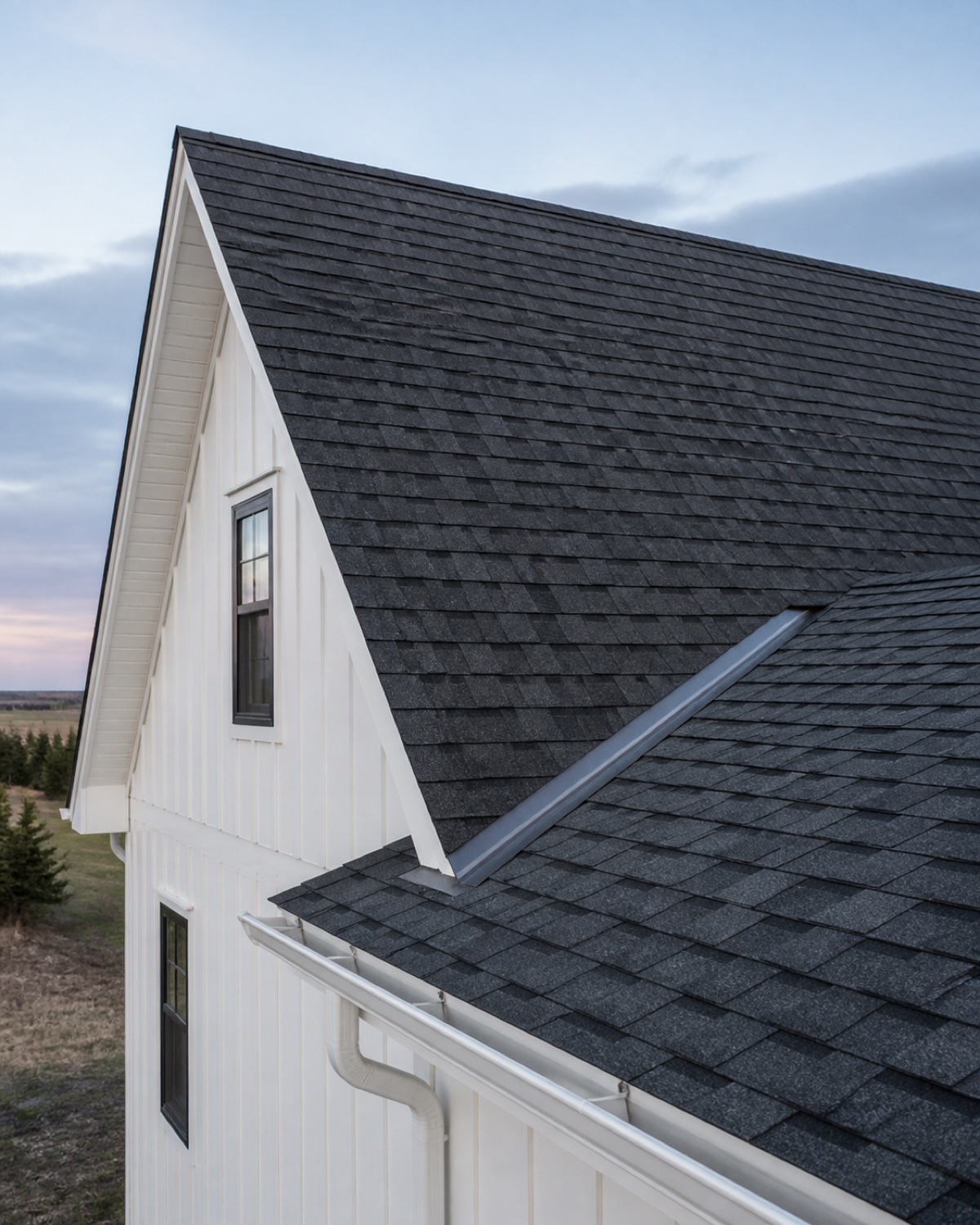 Close view of clean architectural shingles, roof flashing, and gutters on a northern home