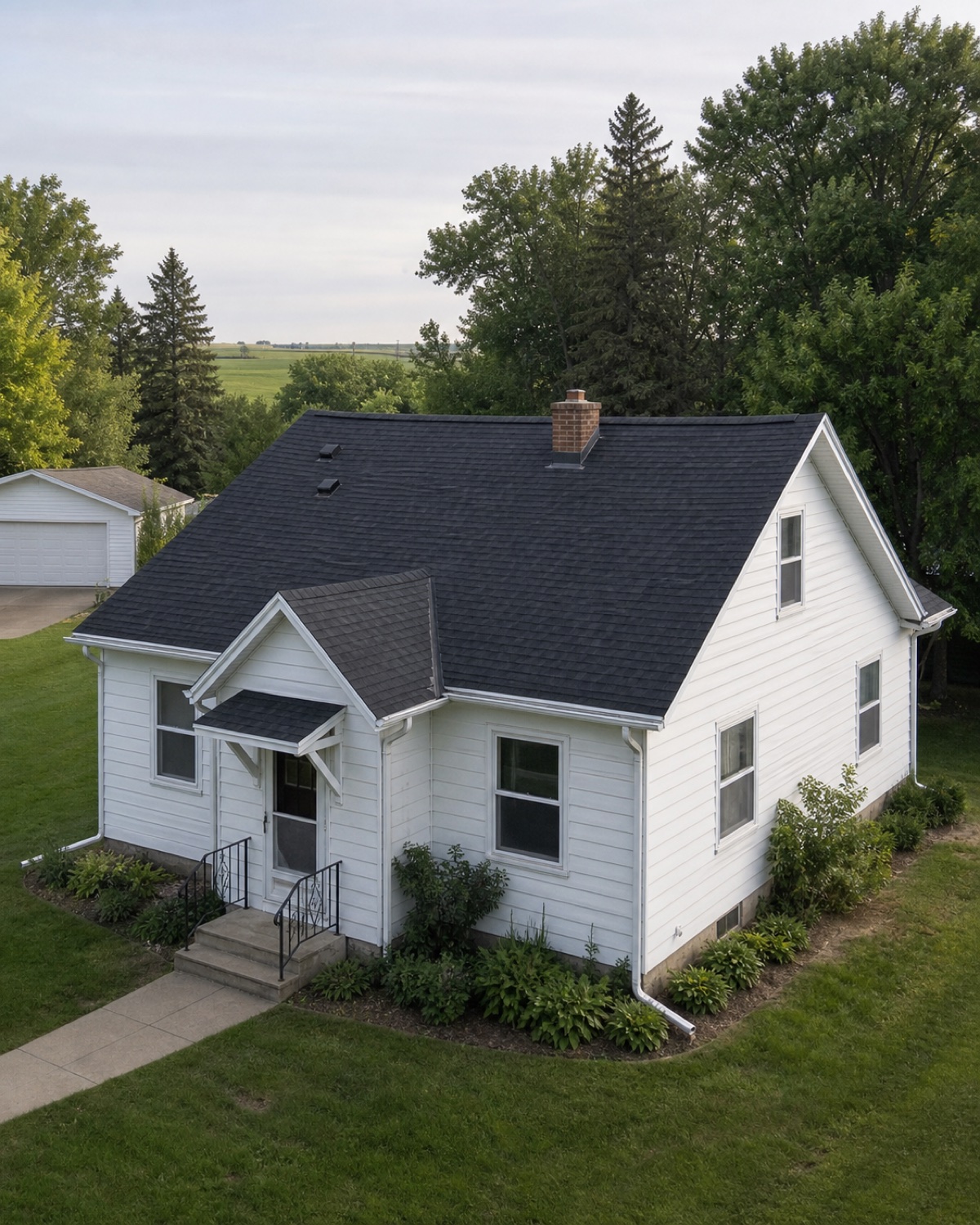 Older gabled Rugby home with dark shingles, white gutters, and modest lap siding